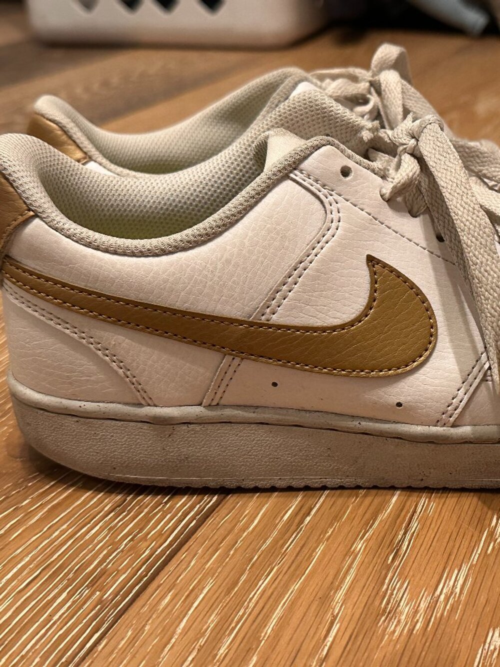 Nike Court Vision Low sneakers in a white and metallic gold